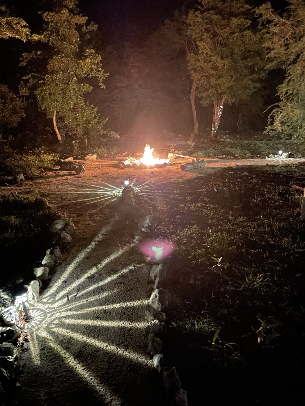 Campfire glowing at night at Aluxes Jungle Sanctuary.